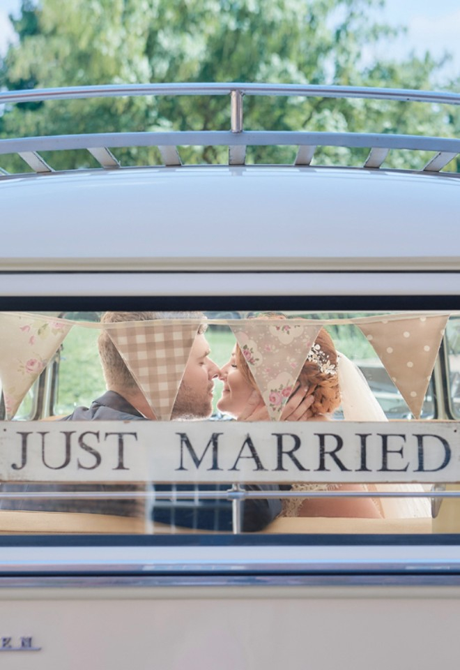 Wedding couple in Volkswagen Beetle with just married sign in the rear window by Stuart Wood Photography