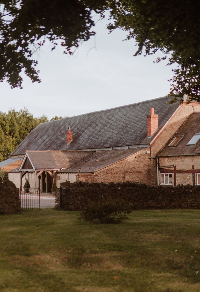 The grounds and barn at an exclusive Oxfordshire barn wedding venue
