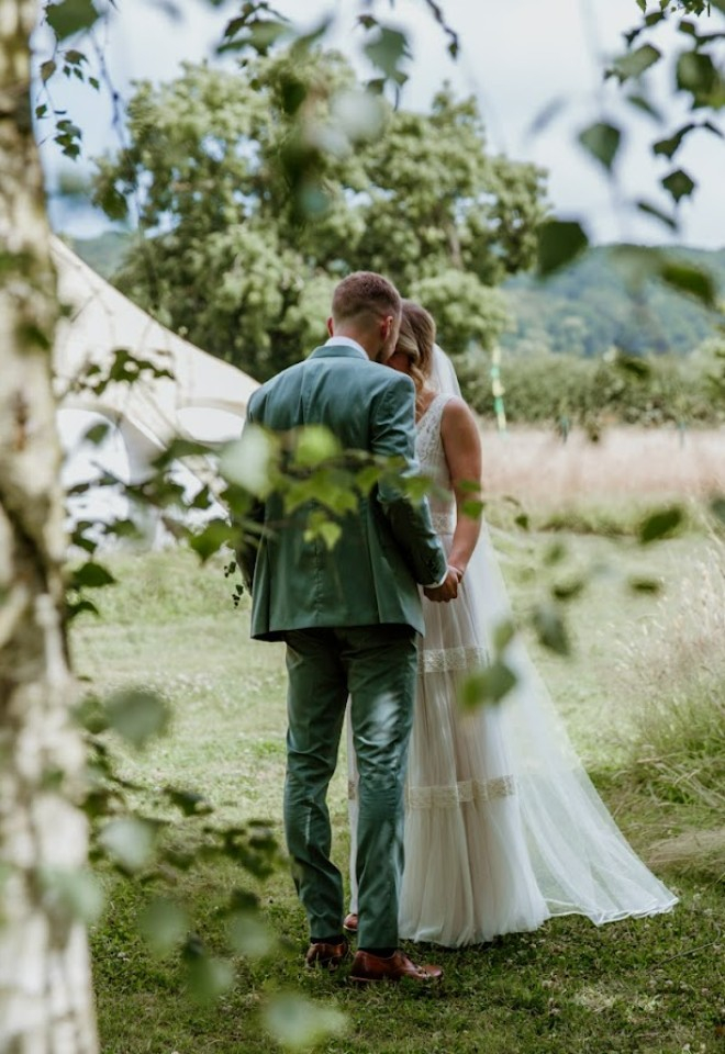 Bride and Groom in an embrace on the grounds of Higher Holcombe wedding venue
