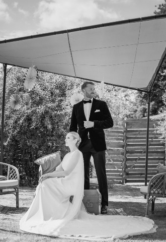 Bride and groom posing in their wedding outfits 