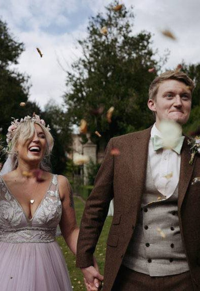 Bride and groom outside of Hockwold Hall wedding venue in Norfolk with flowers and confetti