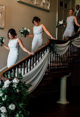 Bridesmaids walking down the staircase at Howsham Hall, North Yorkshire