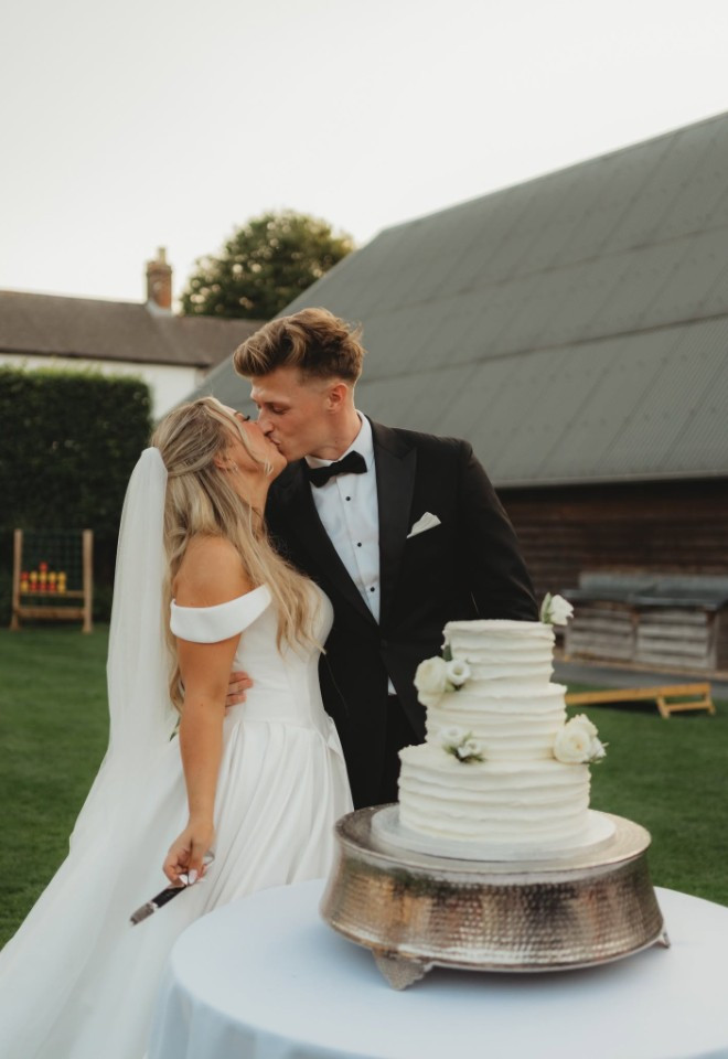 bride & groom cutting a 3 tiered wedding cake at Southend Barns wedding venue Chichester, Sussex