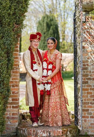 Bride and groom pose in the gardens at Nether Winchendon House