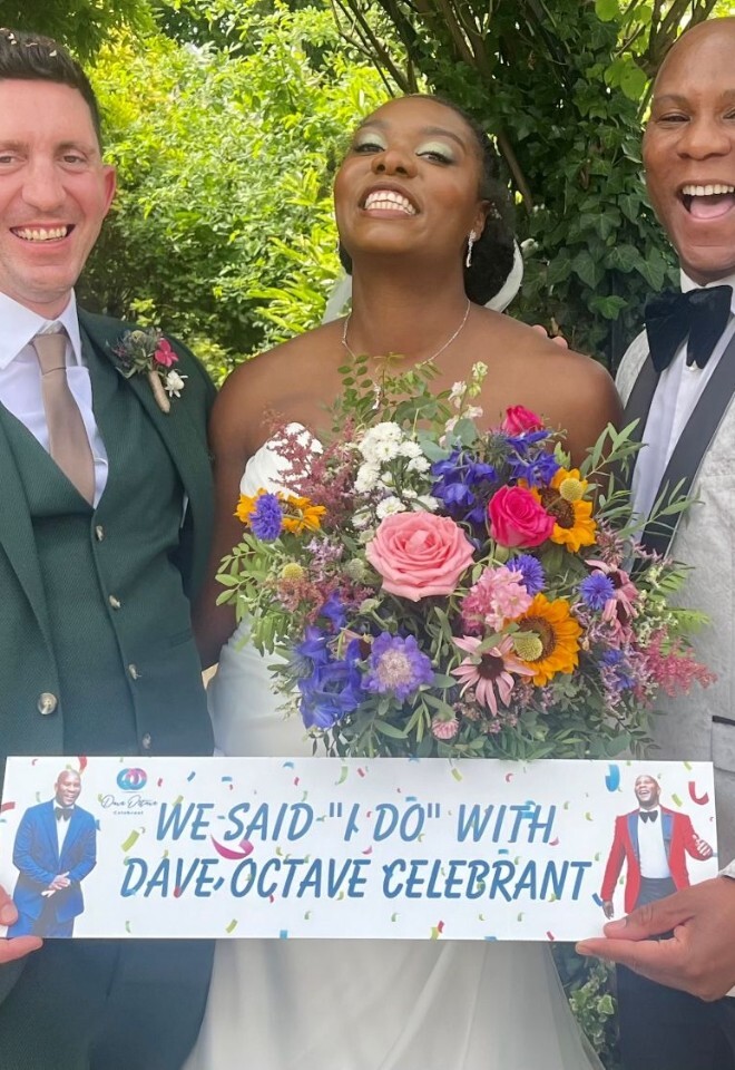 Dave Octave Celebrant with a happy bride and groom smiling and holding my We said I Do with Dave Octave Celebrant sign.
