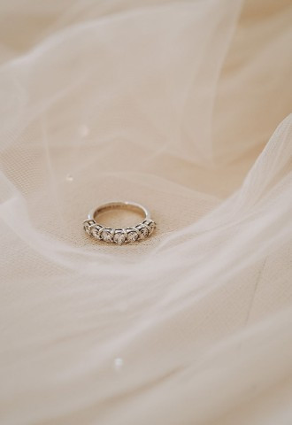 Diamond wedding ring sitting on wedding veil Anelli Ltd