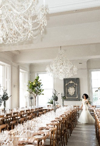 Bride in wedding breakfast room with long tables