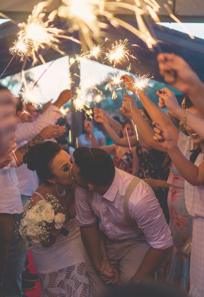 Wedding guests holding sparklers as the bride and groom celebrate during a sparkler exit by Berkshire-based Star Fireworks