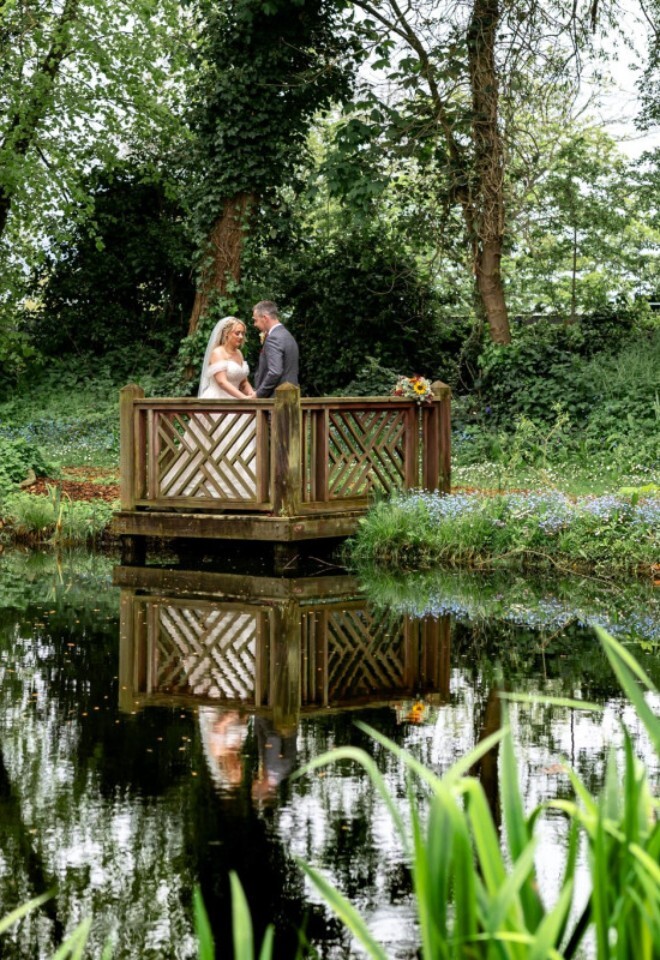 Couple on bridge overlooking the lake at TheLittle Fox Pub Wedding Venue in Merseyside