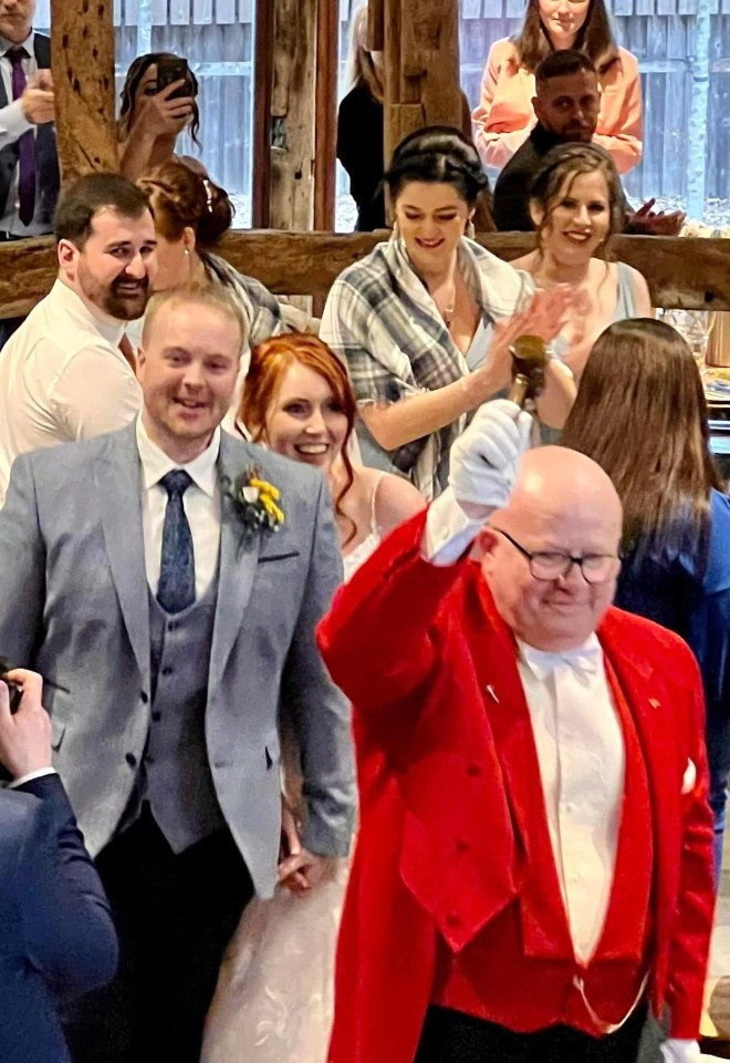 Surrey wedding toastmaster and celebrant Toastmaster John leading the newlyweds into their wedding reception as guests applaud their arrival.