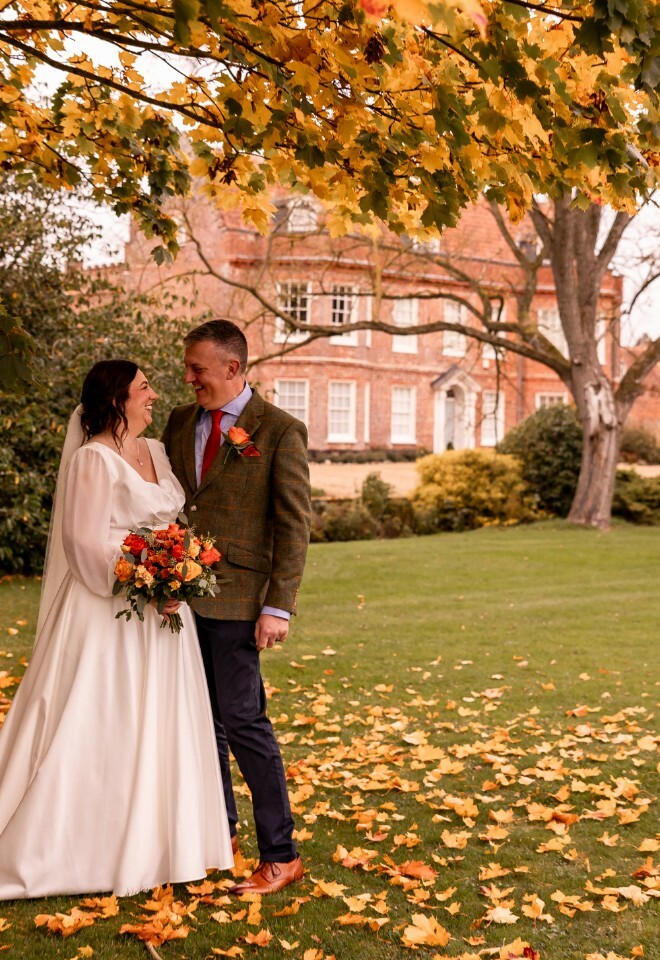 November Wedding at the front of the manor house under the autumnal trees 