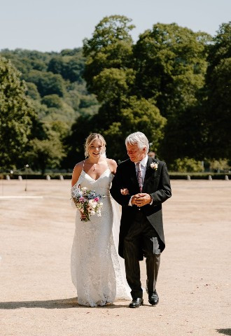 Bride walking down the aisle at her outdoor wedding ceremony, Bisham Abbey, Berkshire