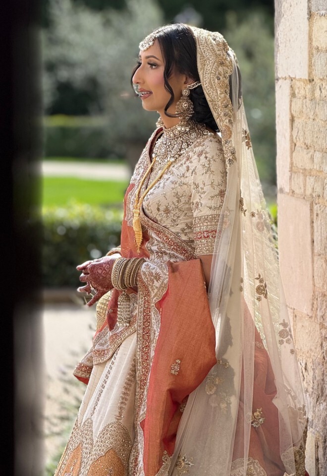 Bengali bride in traditional wedding attire with henna and bridal jewellery, captured in a calm behind-the-scenes bridal moment.