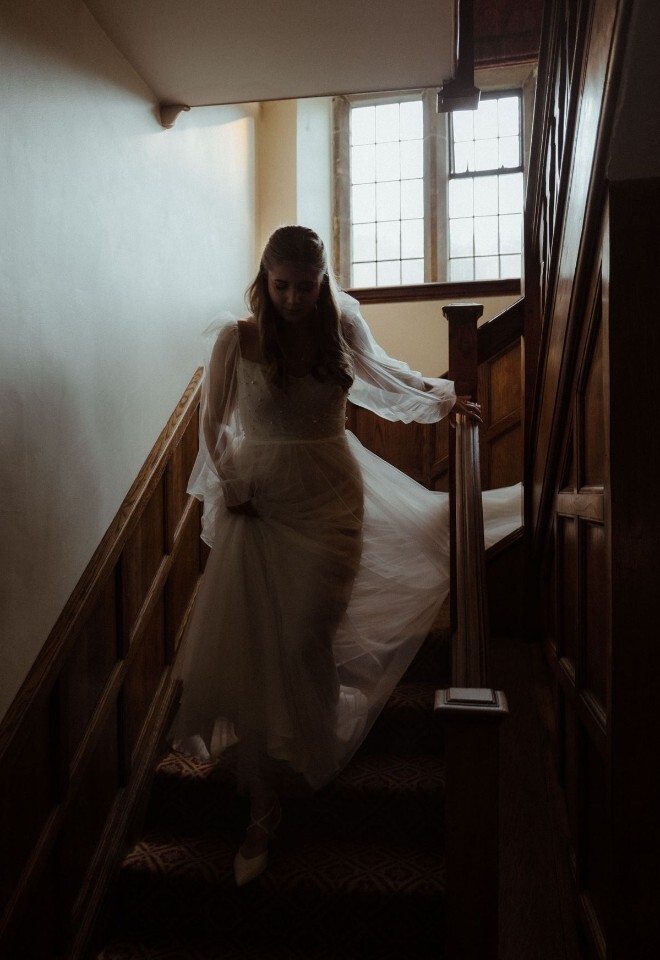 Bride coming down the stairs at Buckland Manor 
