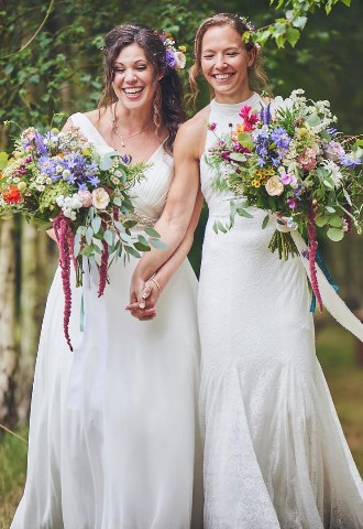 Female gay outdoor wedding in woodlands at Higher Holcombe in Devon. brightly coloured wedding bouquets and hair pieces for the brides.