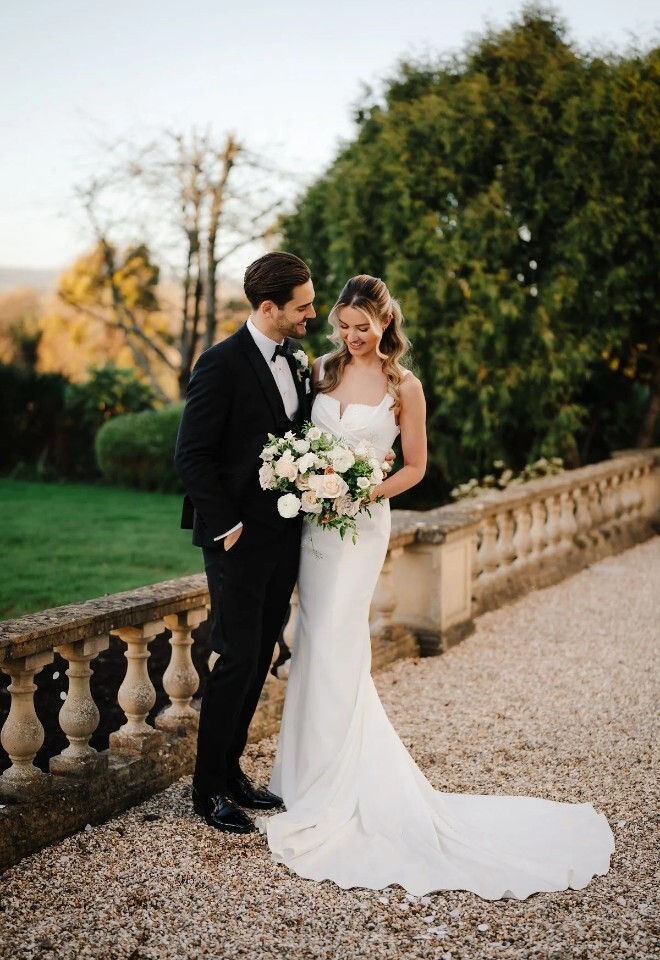 Newlywed couple walking together in the gardens of Henlade House wedding venue in Somerset, with countryside views near Taunton.