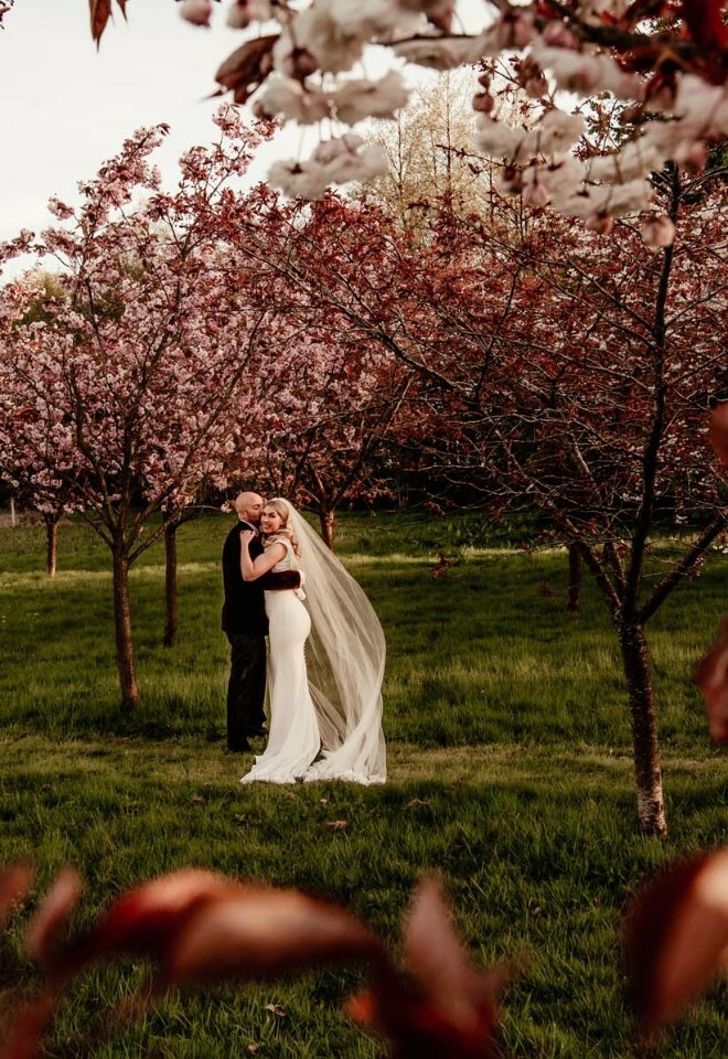Bride and groom embracing in garden