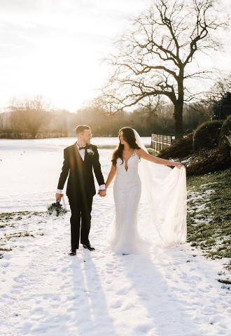Bride and groom walking in the snowy grounds at Reigate Hill Golf Club, Surrey