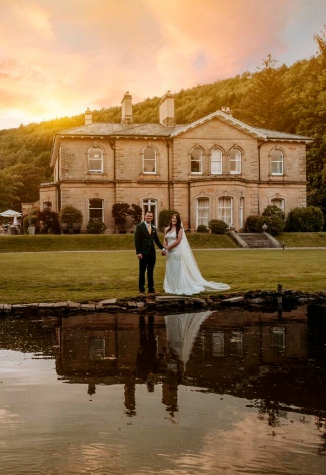 Couple photographed in front of the venue with sunset