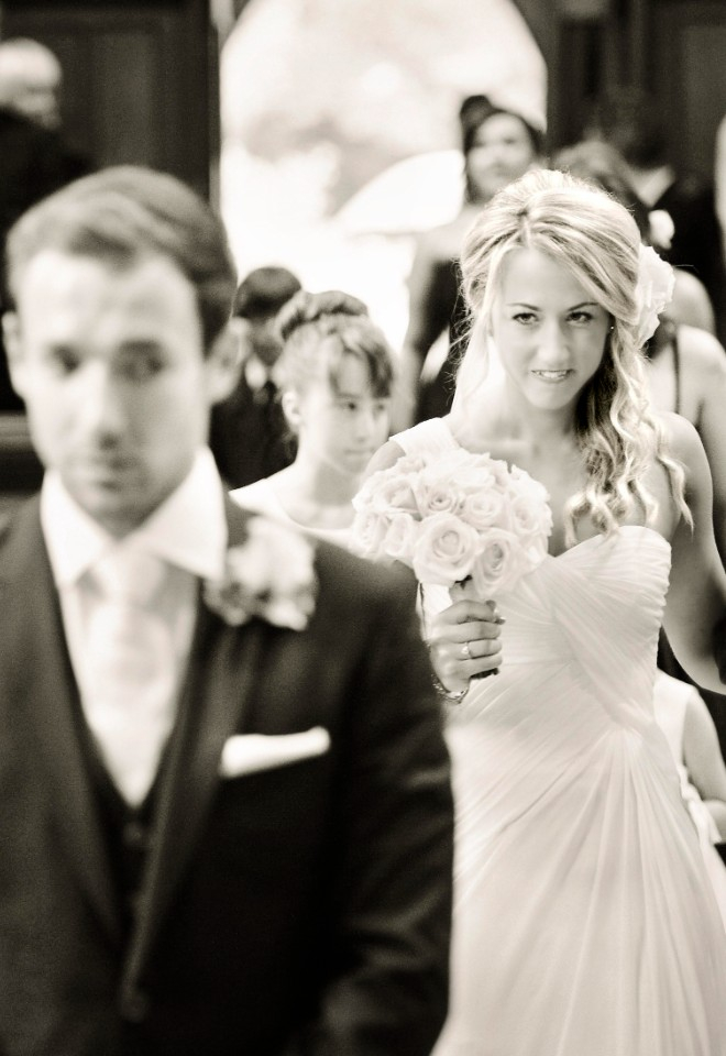 Bride walking down the aisle glancing at groom by Stuart Wood