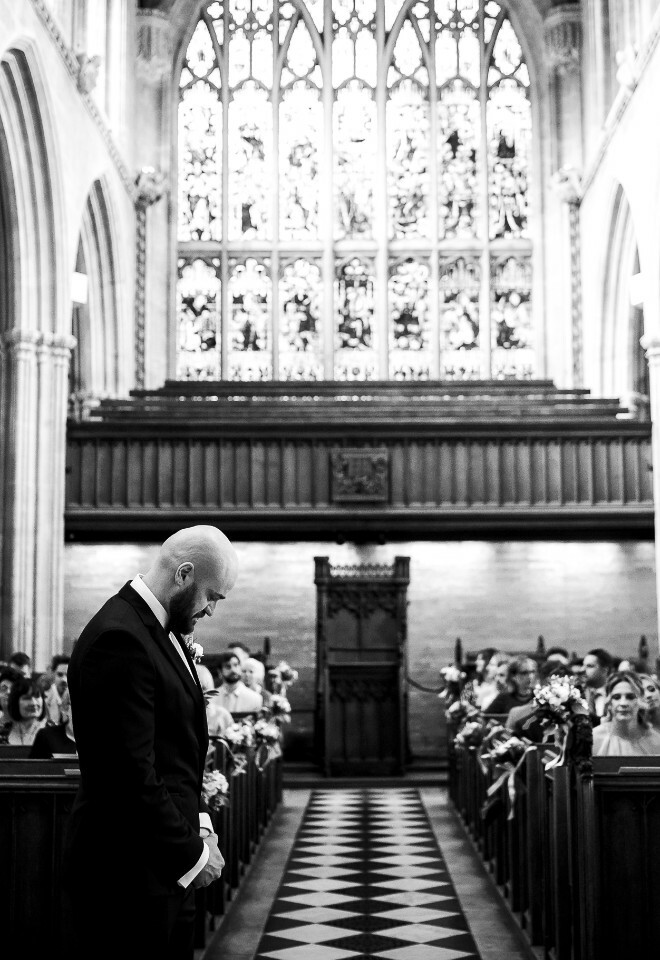 groom waiting in grand oxford church black and white
