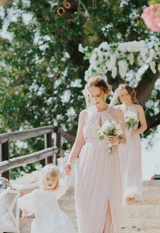 bridesmaids arriving at the wedding ceremony down some steps in cyprus