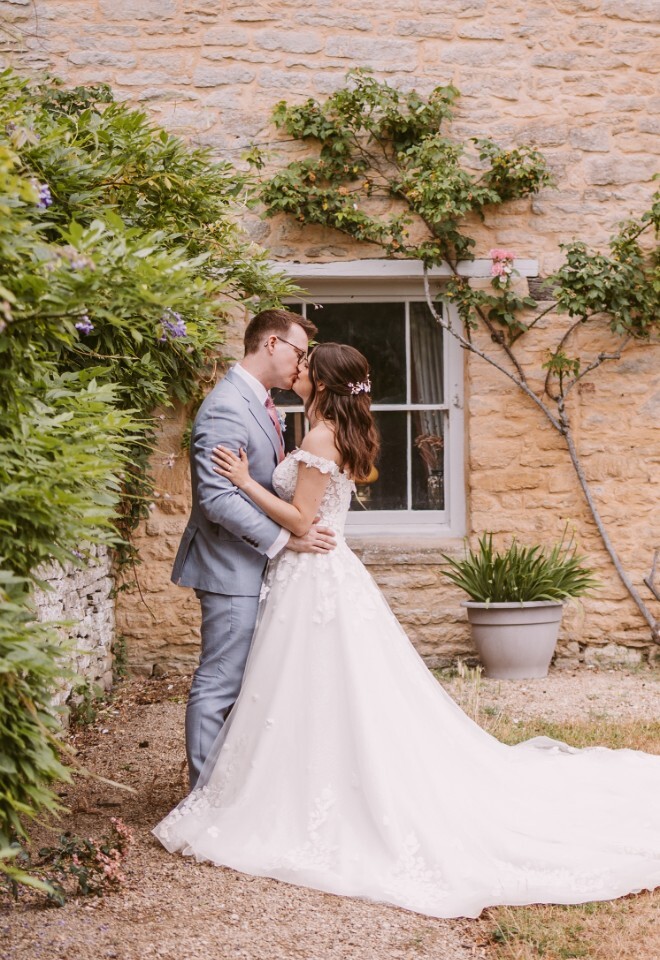 Bride and Groom kissing at Cogges Manor Farm on wedding day