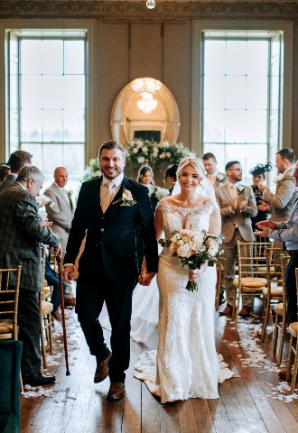 Bride and groom leaving their weddding ceremony at Howsham Hall, Yorkshire