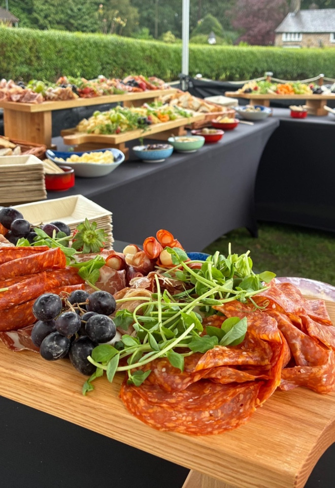Antipasto grazing table with cured meats, cheeses, salads and fresh fruit at a wedding