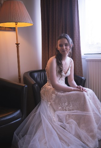 Bride sitting by window on wedding day at Britannia Waterside Hotel Peterhead