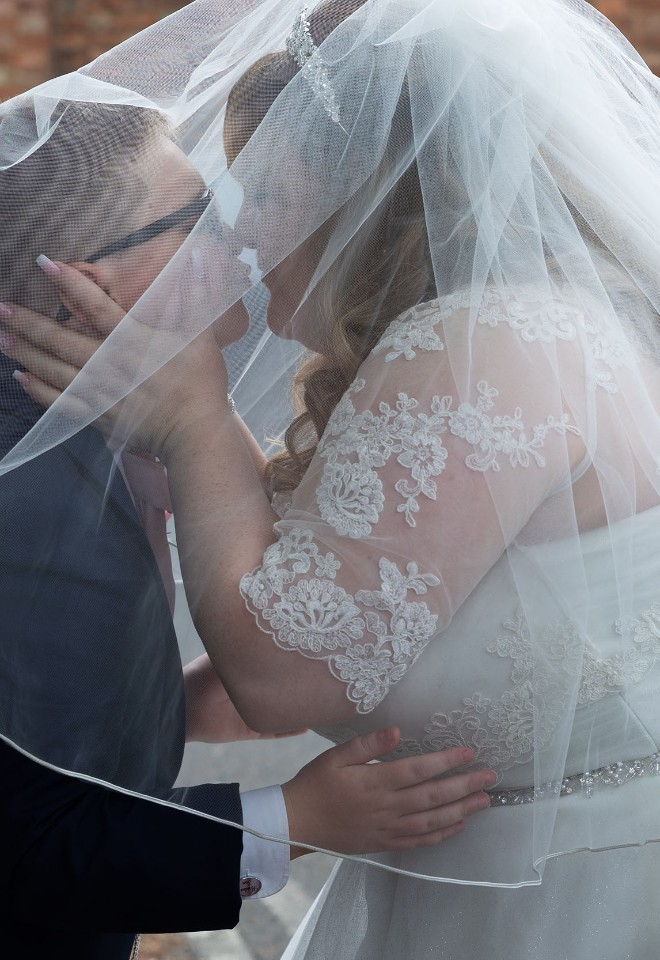 Bride kisses her son, who was awaiting her arrival outside the church, underneath her veil