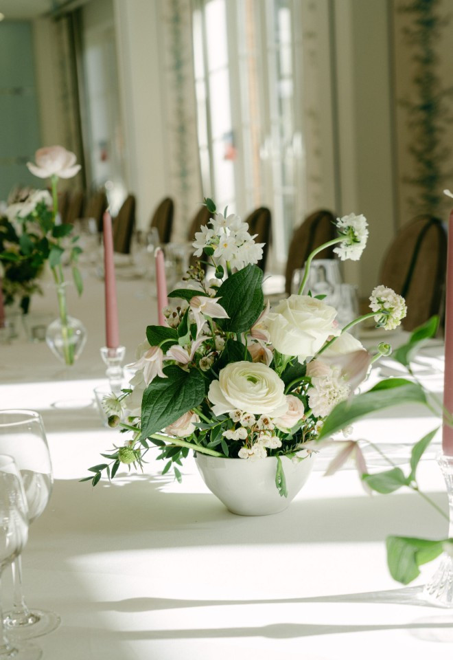 Wild Fig Flowers wedding table arrangement in Oxfordshire, featuring white and soft blush flowers with natural greenery and pink candles.