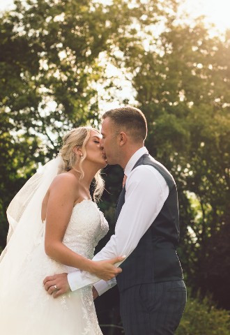 bride and groom sharing a kiss during their wedding photography at golden hour in north wales andrew baines wedding photography
