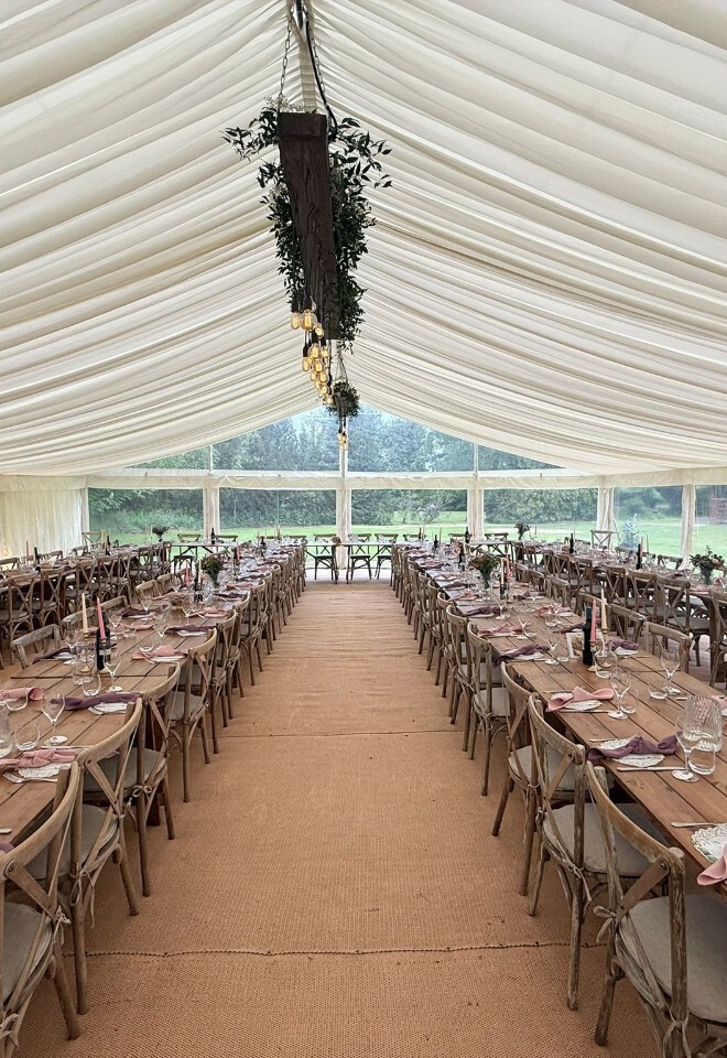 Beautifully styled wedding marquee featuring long banquet tables, rustic décor, elegant table settings and a luxury countryside wedding reception layout.