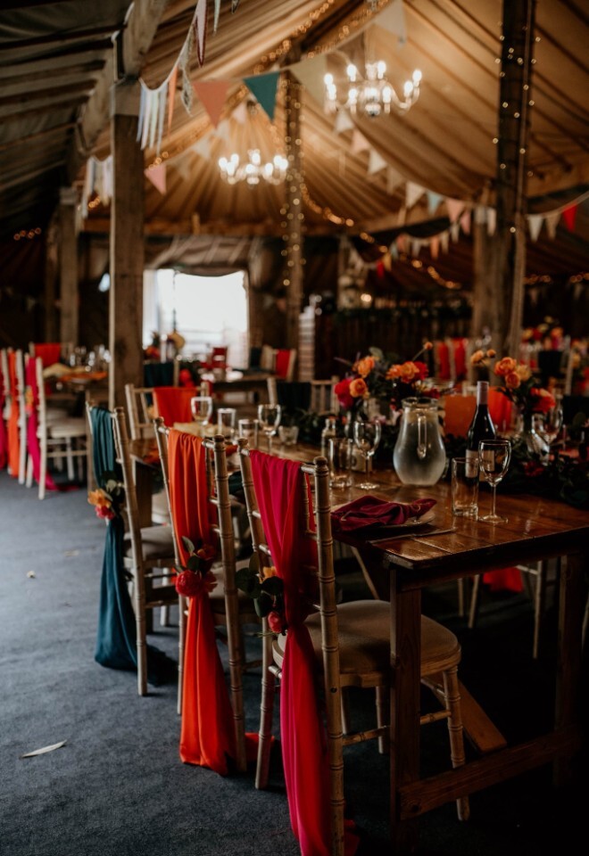 autumnal feel wedding decor at bennetts willow barn worcestershire, red, orange and green chair sashes with rustic barn look