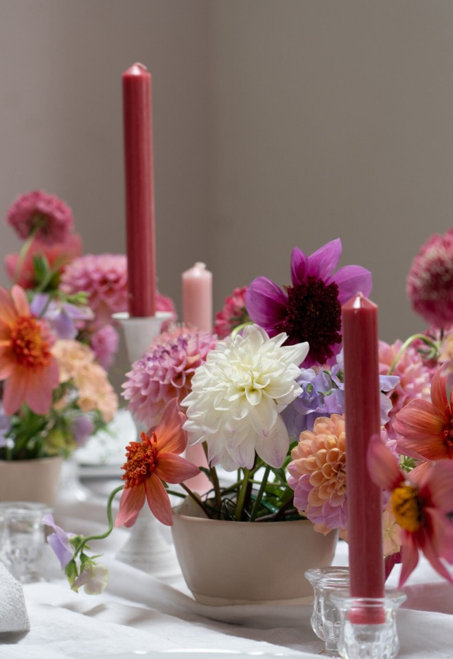 Wild Fig Flowers colourful wedding table flowers in Oxfordshire, featuring pink, peach, purple and white dahlias with coordinating candles.