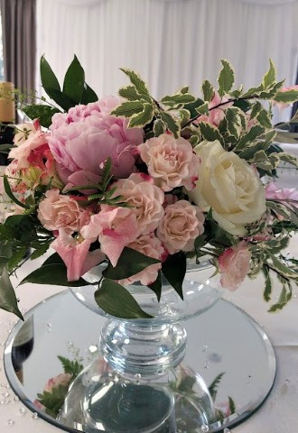 Pretty pink table arrangement in low bowl, full of peonies, roses and sweetpeas