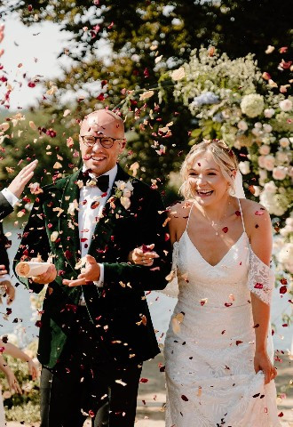 Bride and groom being showered in confetti at Bisham Abbey, Berkshire