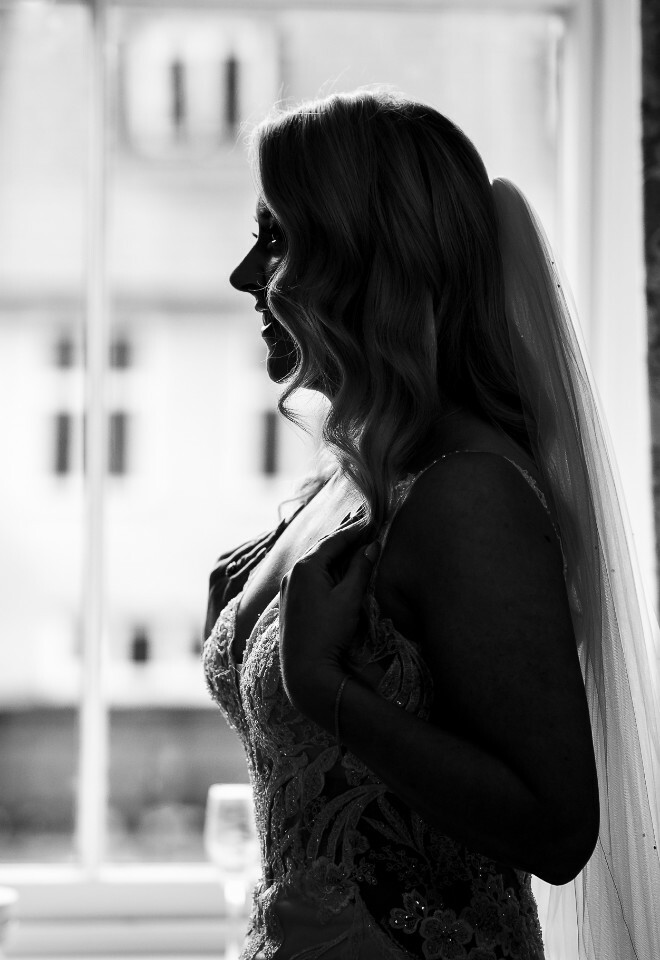 bride in dress at window