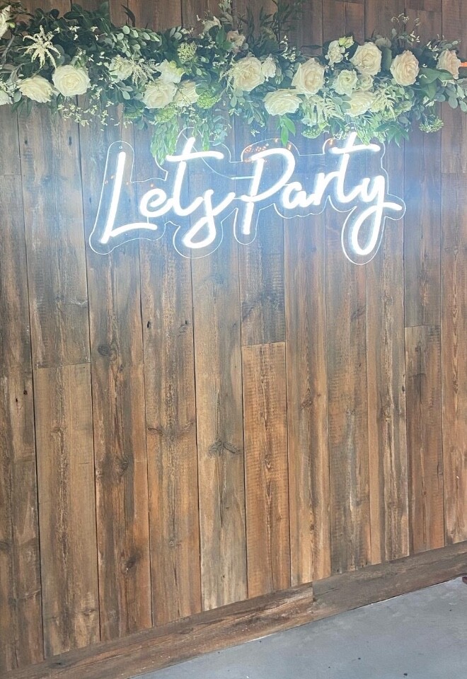 Let’s party neon sign with fresh flowers 