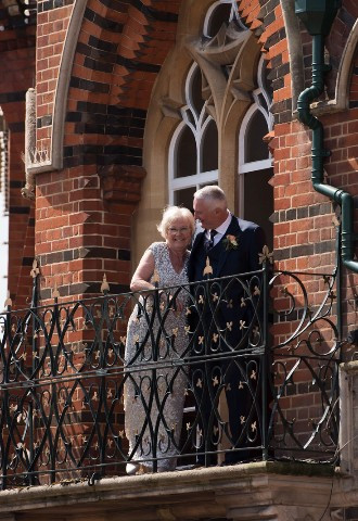 Bride and groom pose on a balcony at Wokingham Town Hall, Berkshire