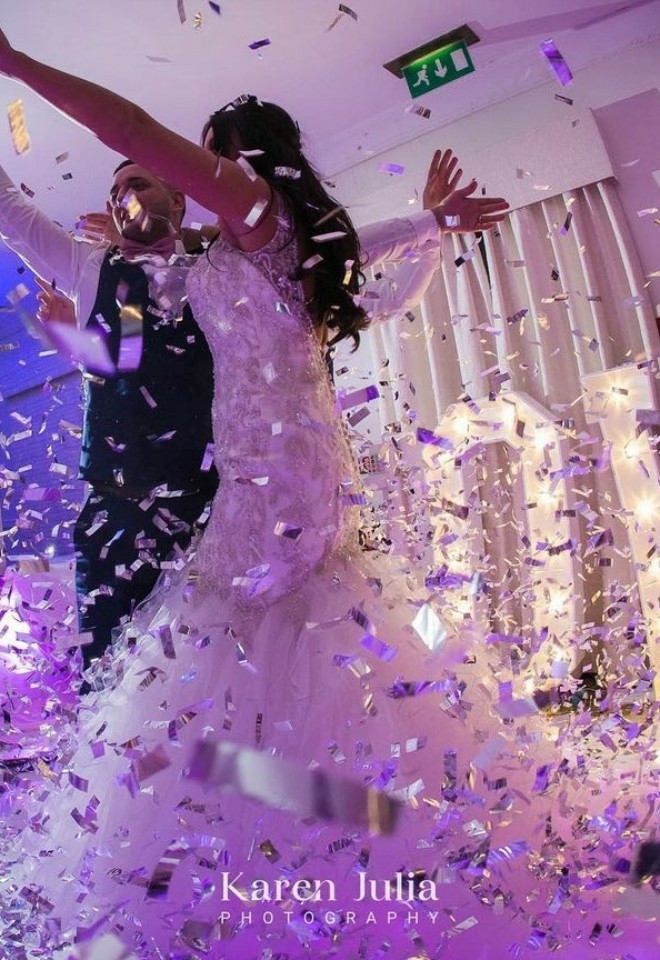 Bride and groom dancing amongst confetti
