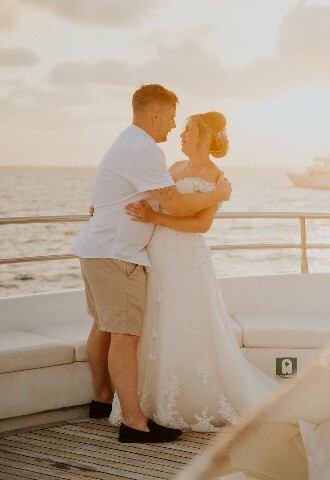 bride and groom pose at sunset on a yacht in cyprus