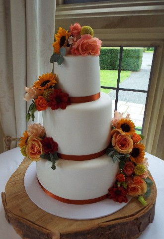 Three tier fondant icing wedding cake with orange fresh flower decoration, Gails Cake Pantry