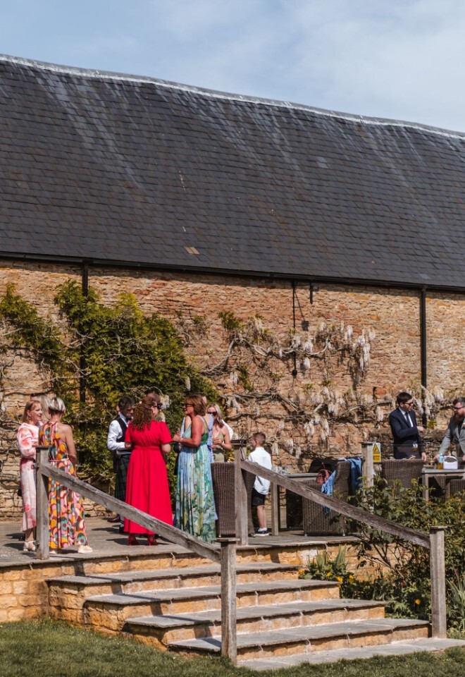 Wedding guests enjoying their time outside the barn at an Oxfordshire wedding venue