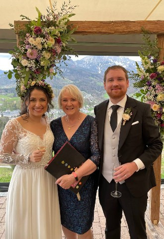 Salzbergalm Bavaria. Celebrant stands between bride and groom with a toast after their ceremony on a mountain in Austria