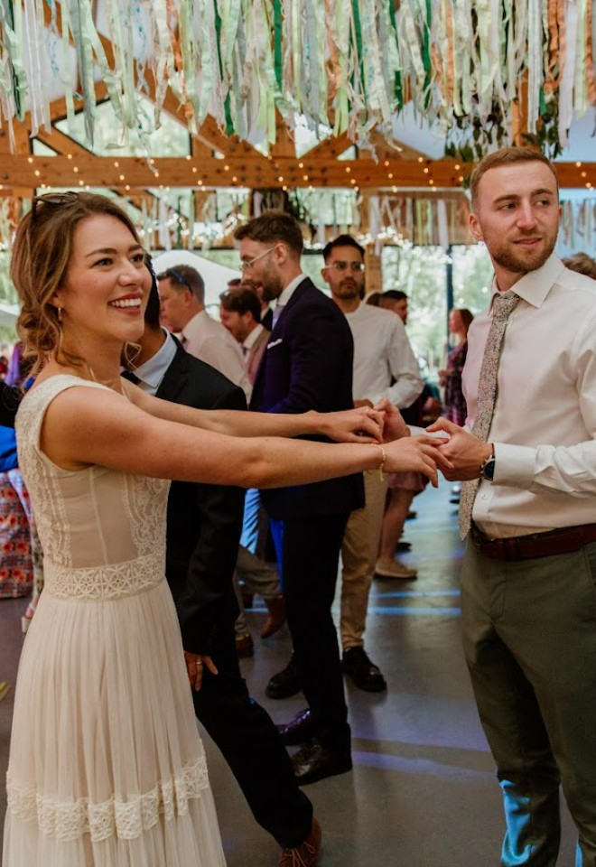 Bride and groom holding hands in the barn wedding venue 