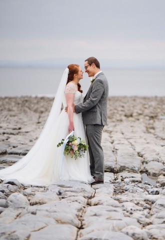 Bride and groom pose for their wedding photos on Llantwit Major Beach, South Wales