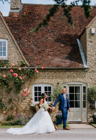 bride and groom in front of Oxfordshire farmhouse