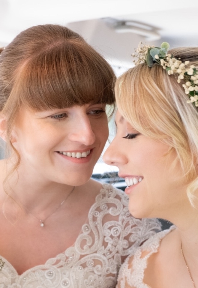 Two brides in a wedding car arriving at their wedding 